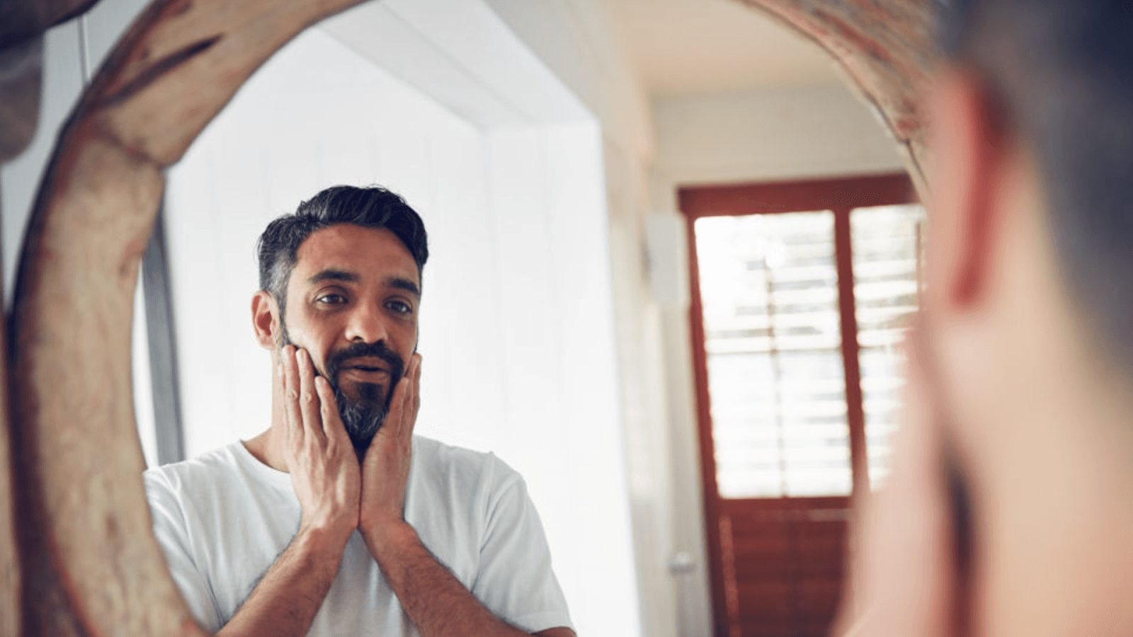 a man looking into his mirror